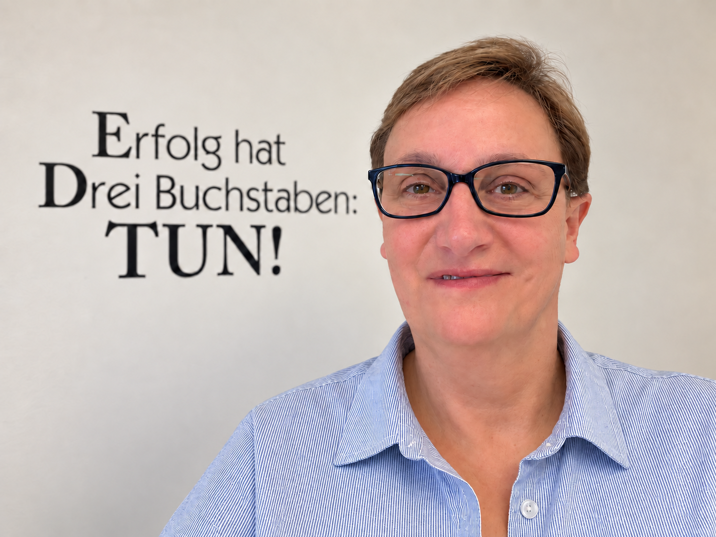 Maria Beckmann in ihrem Büro vor dem Spruch Erfolg hat Drei Buchstaben: TUN!